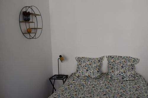 a bedroom with a bed and a lamp and a white wall at Studio Championnet, balcon, haut confort in Grenoble