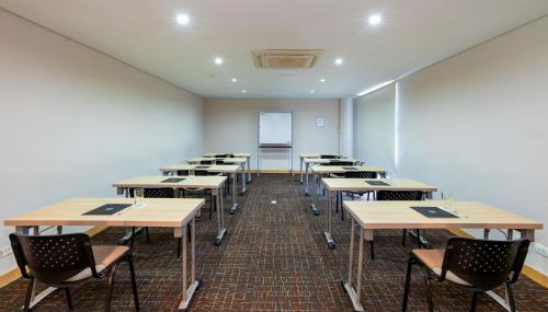 an empty classroom with tables and chairs and a chalkboard at bh Barranquilla in Barranquilla