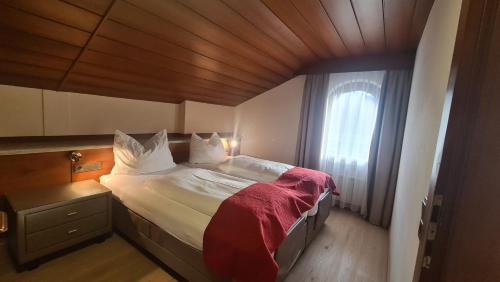 a bedroom with a large bed with a wooden ceiling at Hotel Tyrolis in Zirl