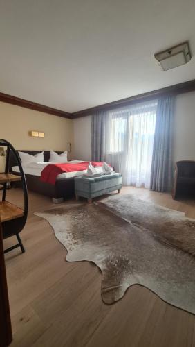 a bedroom with two beds and a rug on the floor at Hotel Tyrolis in Zirl