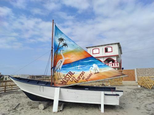 - un bateau sur la plage avec un tableau dans l'établissement Hostal LAS GARZAS DEL PELADO, à Playas