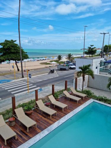 a swimming pool with chairs and a view of the beach at Kastel Jampa Hotel in João Pessoa