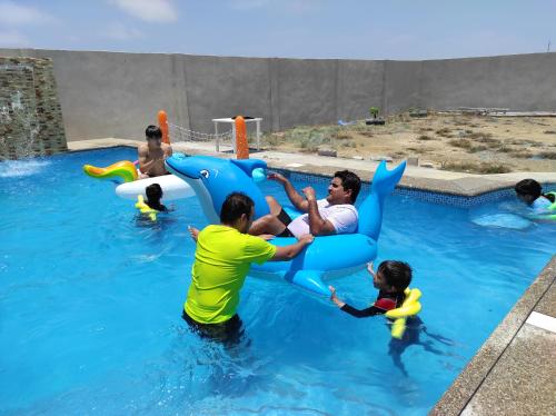 a group of people playing in the water on at Hostal LAS GARZAS DEL PELADO in Playas