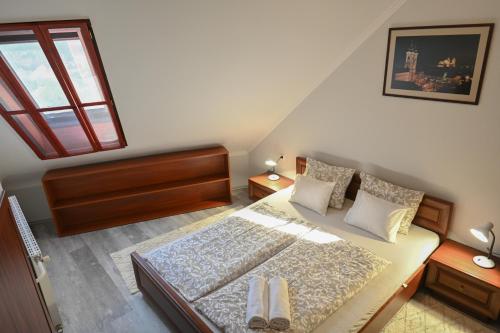 a small bedroom with a bed and a window at Borbarát Vendégház in Eger