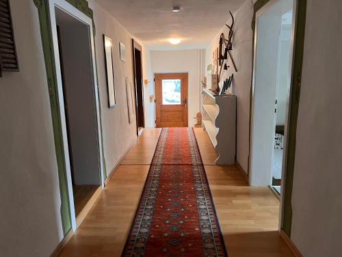 a hallway with a rug on the floor and a door at Ferienhaus Gertrud in Nesselwängle