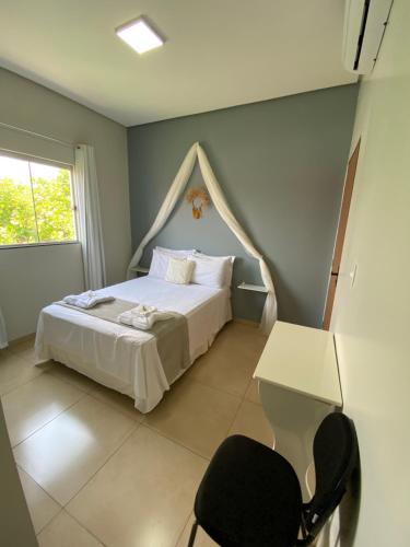 ein Schlafzimmer mit einem weißen Bett und einem Stuhl in der Unterkunft Ventanas Hotel Boutique in Carolina