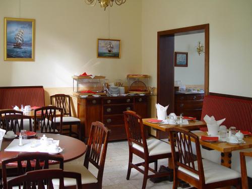 un comedor con mesas, sillas y una barra en Hotel Altes Hafenhaus en Rostock