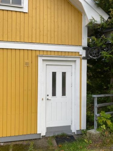 a garage with a white door on the side of a house at Central vindslägenhet med gratis parkering in Lindesberg