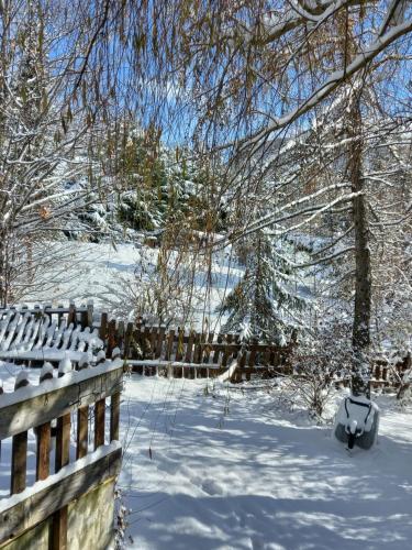 a snow covered yard with a fence and trees at La Méridienne - Chambres d'hôtes in Venterol
