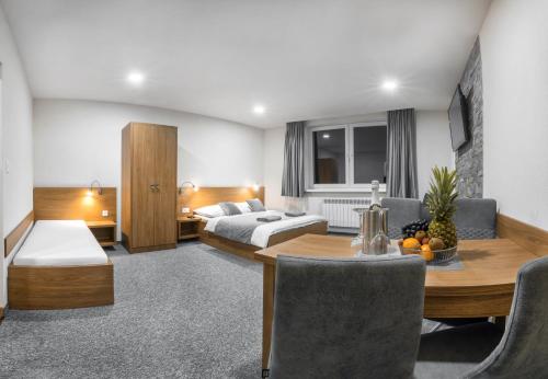 a hotel room with a bed and a table and chairs at Apartmány Sendy in Ždiar