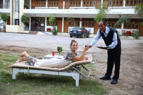 Un hombre está dando a una mujer en una cama en Rezeiky Hotel & Camp, en Luxor