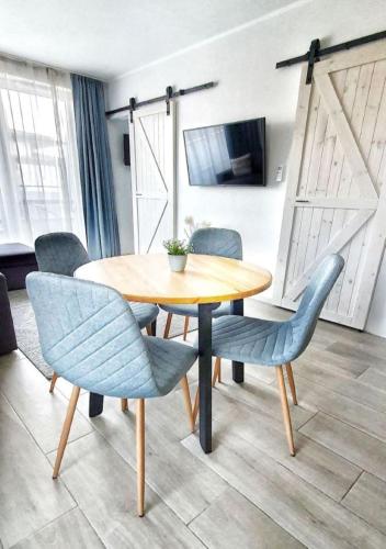 a dining room table with blue chairs in a room at Marina Apartment by Dora in Keszthely