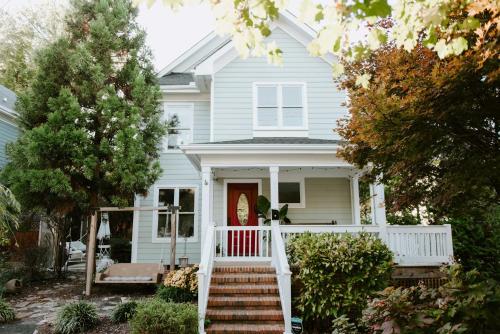 a white house with a red door and stairs at Home with Outdoor Oasis in Downtown Raleigh! in Raleigh
