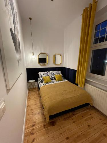 a small bedroom with a bed with yellow pillows at Willa 1936 , Parking in Toruń