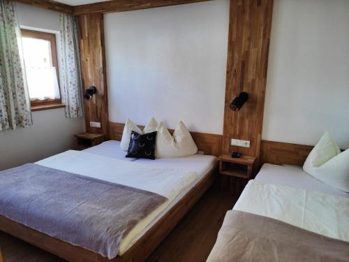 カルテンバッハにあるFerienwohnungen Hochzillertalのベッド2台 木製の壁の部屋