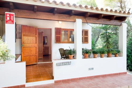 a house with potted plants on the front of it at Apartamentos Molina 9-10-11 in Es Calo