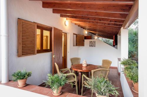 a porch with a wooden table and chairs on a patio at Apartamentos Molina 9-10-11 in Es Calo