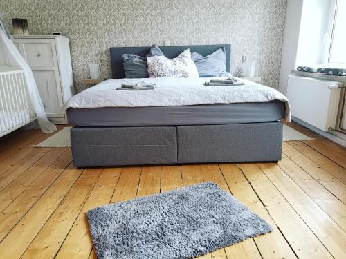 1 cama en un dormitorio con suelo de madera en Landidylle Mertensdorf - Ferienwohnung en Triglitz