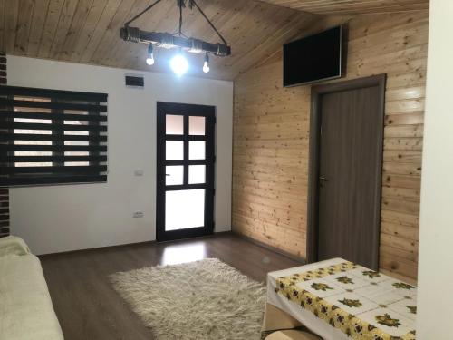 sala de estar con sofá y puerta en La cabana, en Ocnele Mari