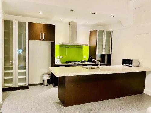 a kitchen with a sink and a counter top at Gamma Hotel in Auckland