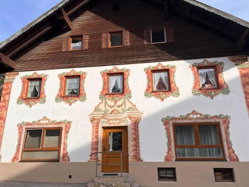 a house with many windows and a wooden door at Ferienhaus Gertrud in Nesselwängle
