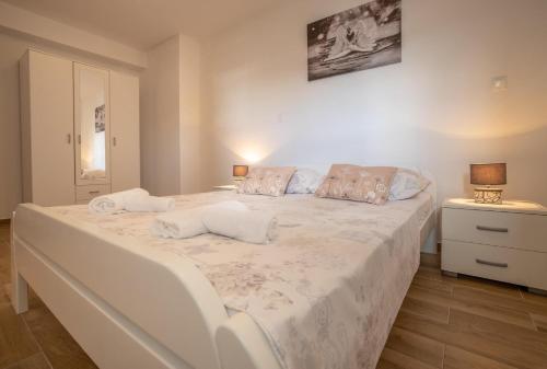1 dormitorio con 1 cama blanca grande y 2 almohadas en Apartman Mila Zivogosce, en Živogošće