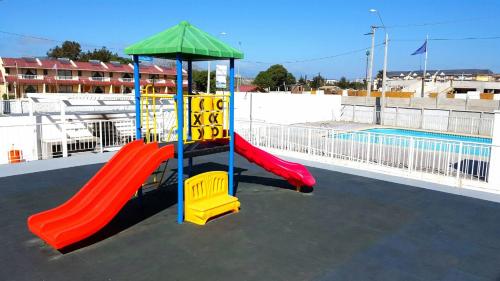 einen Spielplatz mit zwei Rutschen und einem Pool in der Unterkunft Departamento Marina la Serena in La Serena