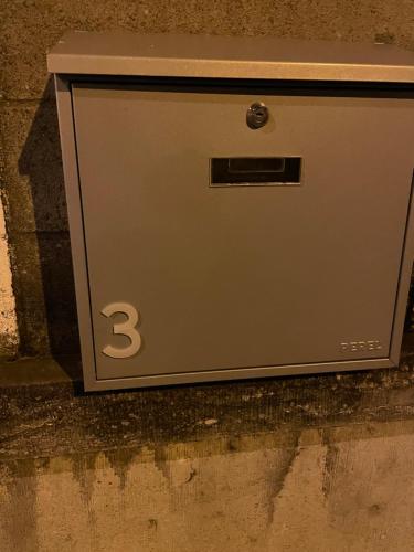 una caja de metal sentada en el lateral de una calle en Room of Tournai, en Tournai