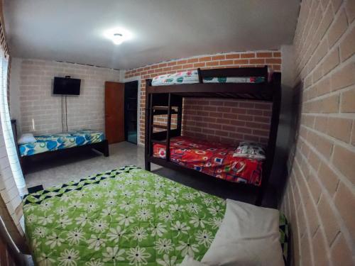 a room with two bunk beds in a brick wall at KasaGrande in Santa Fe de Antioquia