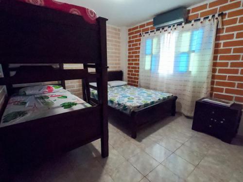 a bedroom with two bunk beds and a window at KasaGrande in Santa Fe de Antioquia
