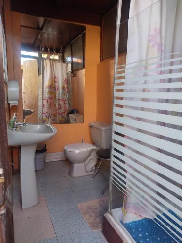 a bathroom with a sink and a toilet and a shower at Hostal Sonchek in San Pedro de Atacama