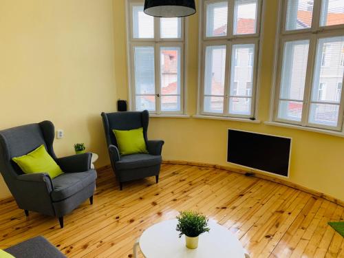 sala de estar con 2 sillas y TV de pantalla plana en TÁNIN HOUSE - Three-bedroom apartment, sauna and gym 10' away from Borovets en Samokov