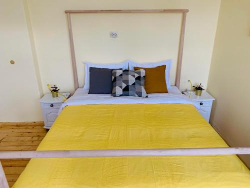 a bedroom with a large bed with a yellow bedspread at TÁNIN HOUSE - Three-bedroom apartment, sauna and gym 10' away from Borovets in Samokov