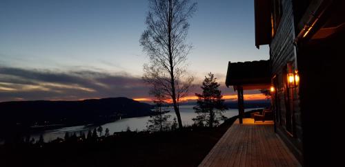 a building with a view of a lake at sunset at Mjøshytte in Stange