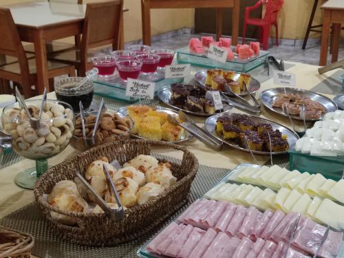 a table topped with lots of different types of food at Hotel São Lucas in Alfenas