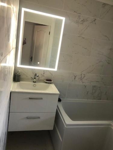 a bathroom with a sink and a mirror and a tub at Beautiful Large ROOM in London Flat in London