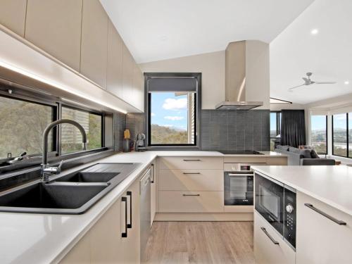 a kitchen with white cabinets and a sink at Black Diamond Retreat - Luxury 3BR Home l Lake Views l Fire Pit l WiFi l Bath in Jindabyne