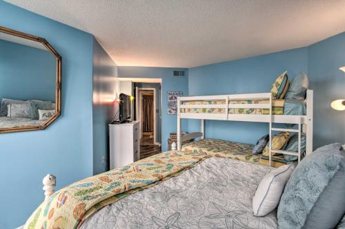 a bedroom with two bunk beds and a mirror at Colorful Beachfront Condo with Resort Amenities in North Topsail Beach