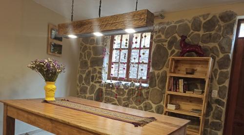 a room with a table with a vase of flowers on it at Doña Catta Casa Boutique in Ollantaytambo