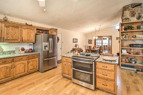 a kitchen with stainless steel appliances and wooden cabinets at 40-Acre Poplar Bluff Nature Lovers Paradise! in Poplar Bluff