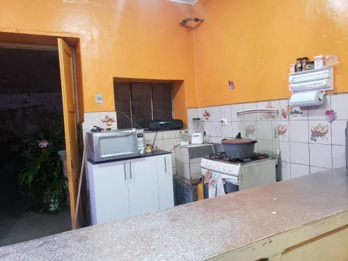 a kitchen with a stove and a microwave at CASA VIEJA del Centro Historico in Quito