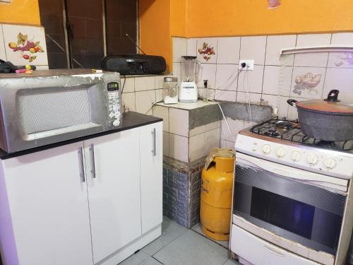 a kitchen with a microwave oven and a stove at CASA VIEJA del Centro Historico in Quito