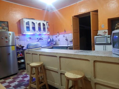 a kitchen with a counter and two stools in it at CASA VIEJA del Centro Historico in Quito