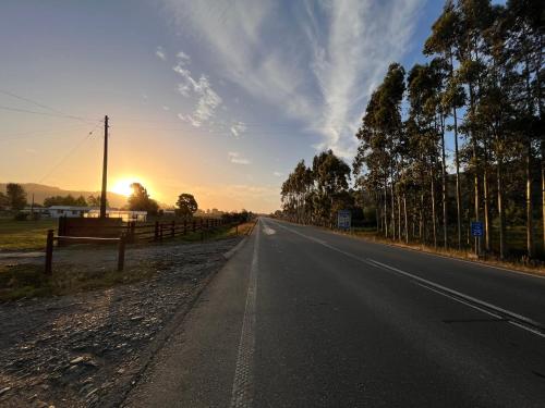 an empty road with the sunset in the background at Mehuín el Remanso de Paz in Mehuín