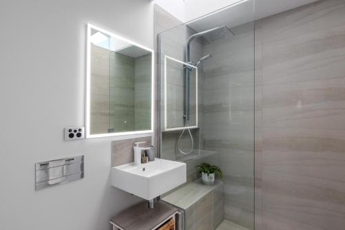 a bathroom with a sink and a mirror and a shower at Cashmere Heights in Christchurch