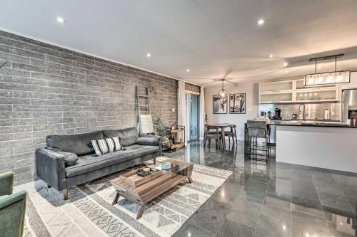 a living room with a couch and a brick wall at Walk to Fashion Square! Snowbird Condo with Pool in Scottsdale