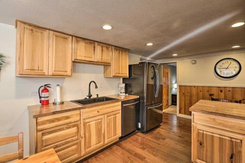 a kitchen with wooden cabinets and a stainless steel refrigerator at Wildmanor Ranch Near Red Rocks with Hot Tub! in Morrison