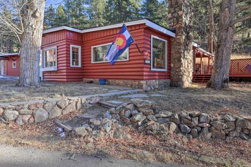 a red cabin with a flag in front of it at Wildmanor Ranch Near Red Rocks with Hot Tub! in Morrison