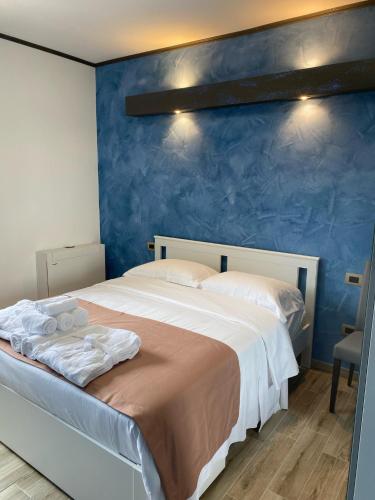 a bedroom with a large bed with a blue wall at Antica Locanda Zio Cesare in Ferrara