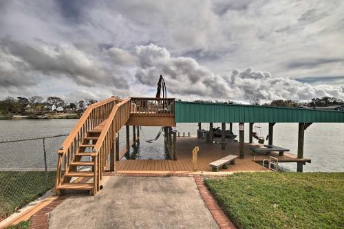 a wooden dock with a ramp on the water at Waterfront San Jacinto River Home with Boat Slip! in Houston